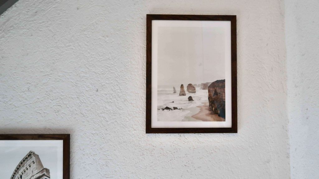 A Photo Wall In The Bedroom With Posters From Poster Store