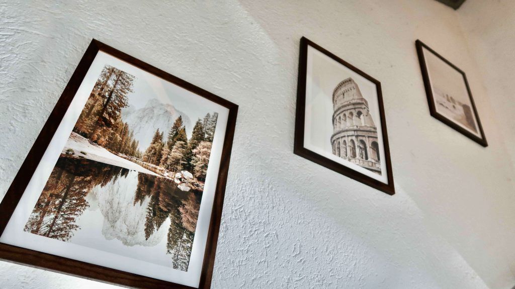 A Photo Wall In The Bedroom With Posters From Poster Store